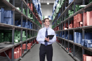 Manager In Warehouse With Clipboard and Safety stock control
